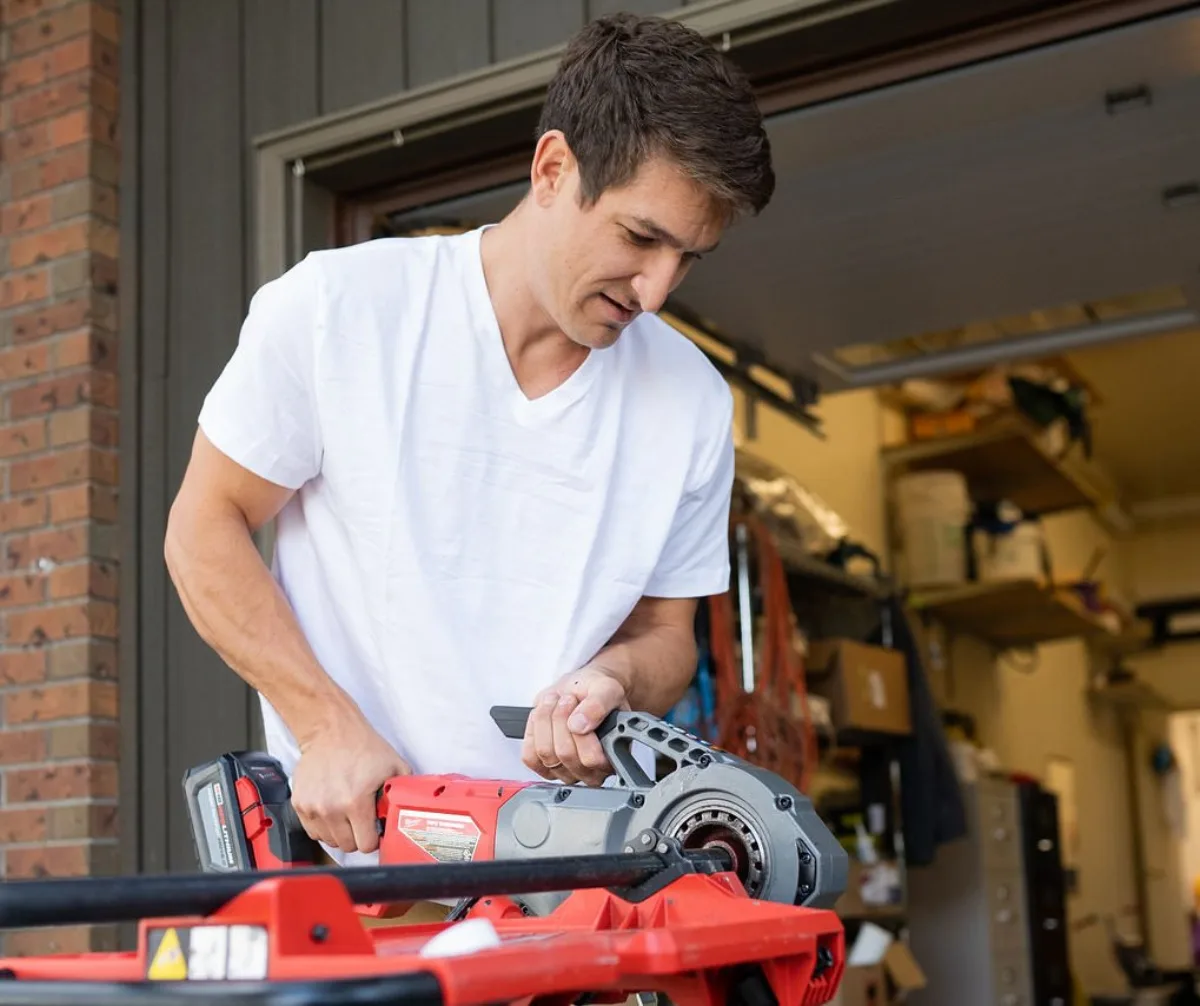 Robert Reid cutting pipe on a plumbing repair job